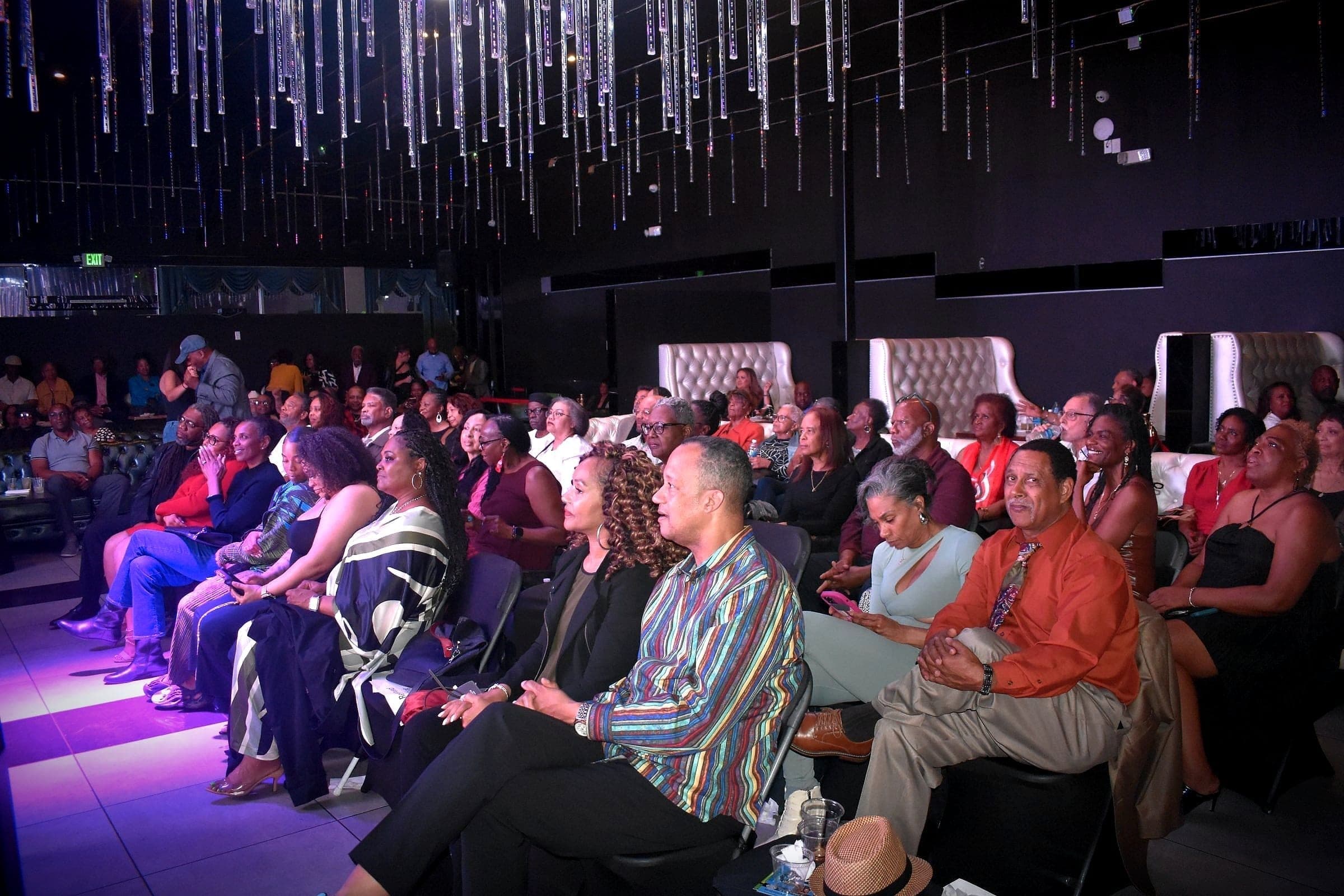 A full house at a First Fridays concert: rows of listeners of all ages, leaning in and watching the stage.
